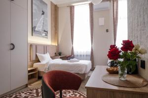 ein Hotelzimmer mit einem Bett und einem Tisch mit Rosen in der Unterkunft Vell7 Hotel in Dzhetyoguz + 138 Fotos