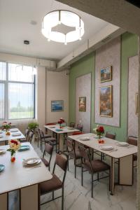 ein Esszimmer mit weißen Tischen und Stühlen in der Unterkunft Vell7 Hotel in Dzhetyoguz