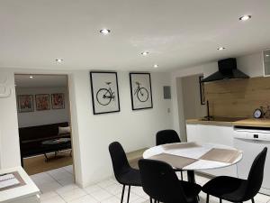 a kitchen and a dining room with a table and chairs at Le Cocoon caché avec piscine parking,terrasse au calme appartement très frais ! in Sarreguemines