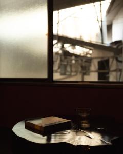 a book on a table next to a window at 刷々 sassa in Osaka