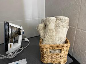 a wicker basket with towels sitting next to a microwave at Le Cocoon caché avec piscine parking,terrasse au calme appartement très frais ! in Sarreguemines
