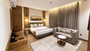 a hotel room with a bed and a couch at Anisa Residence in Salalah