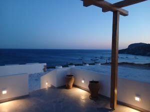a balcony with a view of the ocean at night at Sea Lily Suites Milos in Paleochori