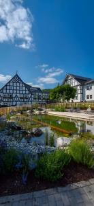 a building with a pond in front of it at Ferienhof Bieke in Finnentrop