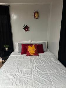 a white bed with a superhero pillow on it at Superhero Family Home Near Downtown Amarillo in Amarillo