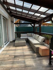 a patio with a couch and chairs on a deck at PEP Apartman in Balatonlelle