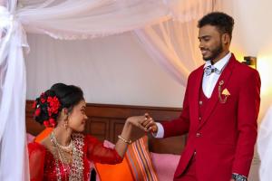 a man in a red suit shaking hands with a woman at Kurumba Lodge in Wilpattu
