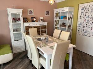 a dining room with a white table and chairs at PEP Apartman in Balatonlelle