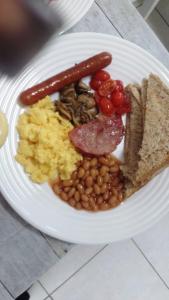 a plate of breakfast food with eggs sausage beans and toast at Blooming Rose Bed and Breakfast in Polokwane +9 photos