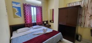 a bedroom with a bed with two towels on it at Hotel Roy's in Shādipur +39 photos