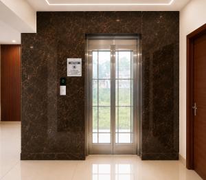 a glass door in a lobby with a window at Nova Alhind Airport Hotel Cochin in Nedumbassery