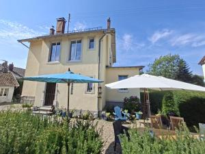 two umbrellas and chairs in front of a house at Villa Amarinis in Saint-Amarin