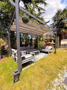 a wooden pergola with two benches and a table at BIOTY CHILL & SPA in Le Blanc-Mesnil
