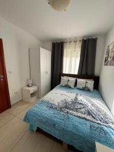 a bedroom with a large bed with a blue blanket at Friends-2 in Risan