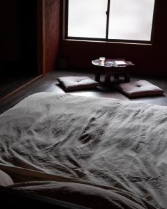 a bed in a room with a table next to it at 刷々 sassa in Osaka