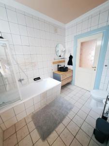 a bathroom with a tub and a toilet and a sink at Sylvia Apartman in Balatonalmádi +25 photos