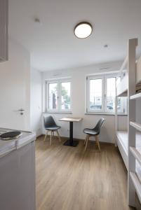 a kitchen and dining room with a table and chairs at smart studios - by kalm stay in Munich