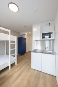 a kitchen with a sink and a bunk bed at smart studios - by kalm stay in Munich +2 photos