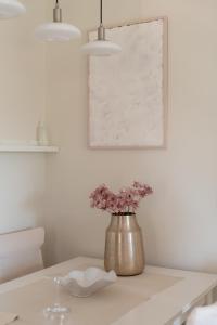 a vase with flowers in it on a table at Naria Home by A&D Properties in Porto Rafti