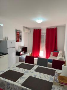 a living room with a table and red curtains at Friends-2 in Risan