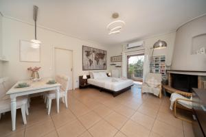 a living room with a bed and a table at Naria Home by A&D Properties in Porto Rafti
