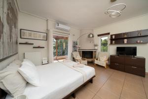 a bedroom with a large white bed and a fireplace at Naria Home by A&D Properties in Porto Rafti +19 photos