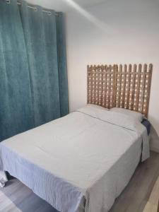 a bedroom with a bed with a wooden headboard at Villa cocooning in Palavas-les-Flots