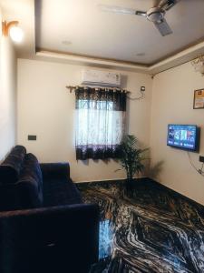 a living room with a couch and a television at Farmview Guest House Netravali in Netorlim