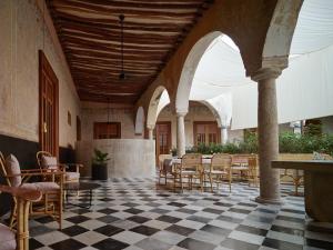a room with chairs and tables in a building at Hotel Sevilla, a Member of Design Hotels in Mérida