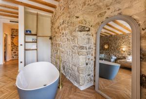 a bathroom with a stone wall and a tub and a mirror at Hotel Heritage Casa Blanka in Makarska +21 photos