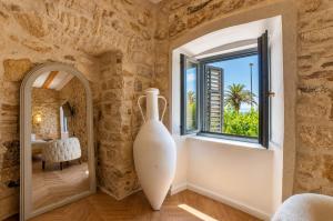 a room with a large white vase next to a window at Hotel Heritage Casa Blanka in Makarska