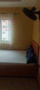 a small bedroom with a bed and a window at Elegance hotel in Ijaiye