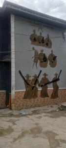 a mural of men with guns on a wall at Elegance hotel in Ijaiye