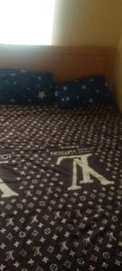 a bedroom with a bed with a letter k on it at Elegance hotel in Ijaiye