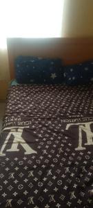 a bed with a black and white comforter on it at Elegance hotel in Ijaiye