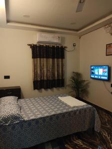 a bedroom with a bed and a television in it at Farmview Guest House Netravali in Netorlim