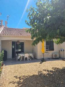 a house with a table and chairs in front of it at Villa cocooning in Palavas-les-Flots