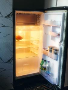 an open refrigerator with food and drinks in it at Farmview Guest House Netravali in Netorlim