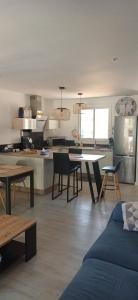 a living room with a table and a kitchen at Villa cocooning in Palavas-les-Flots