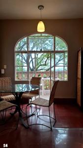 a dining room with a table and chairs and a large window at Suites Santo Domingo in San Miguel de Allende