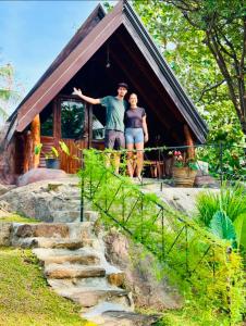a man and woman standing in front of a cabin at Nature Nest Cabana in Sigiriya