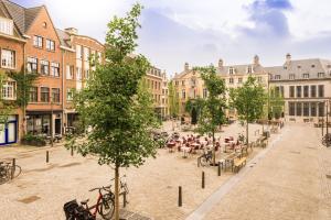 a street in a city with tables and chairs at Leeuwenhof Suites in Antwerp