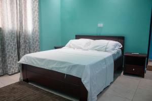 a bed with white sheets and pillows in a bedroom at Bralph-k in Yaoundé