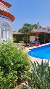 a villa with a swimming pool and a house at casa Costa Dorada in Les tres Cales