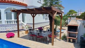 a wooden pavilion with a table and chairs on a patio at casa Costa Dorada in Les tres Cales