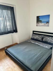 a bedroom with a bed in a room with a window at Tor zur Weinstrasse, Smart & Einfach in Leibnitz