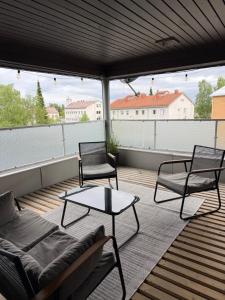 a balcony with two chairs and a couch and a table at Center Hostel Kaatrahovi in Lieksa