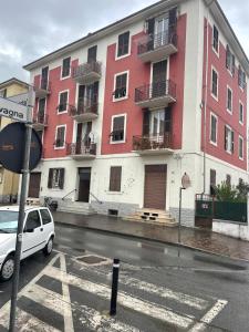 Ein weißes Auto parkte vor einem roten Gebäude in der Unterkunft Corso Martiri in Cairo Montenotte