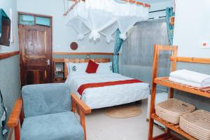 a small bedroom with a bed and a chair at Arusha Giraffe Lodge in Arusha