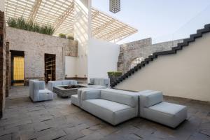 a living room with couches and a staircase at La Purificadora, Puebla, a Member of Design Hotels in Puebla